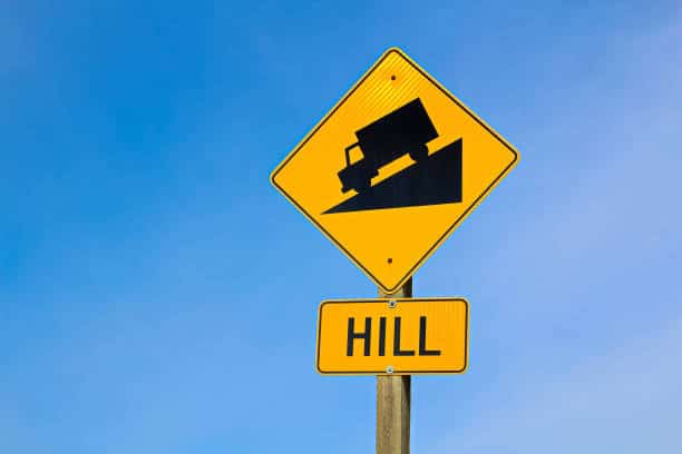 Approaching hill sign along highway.